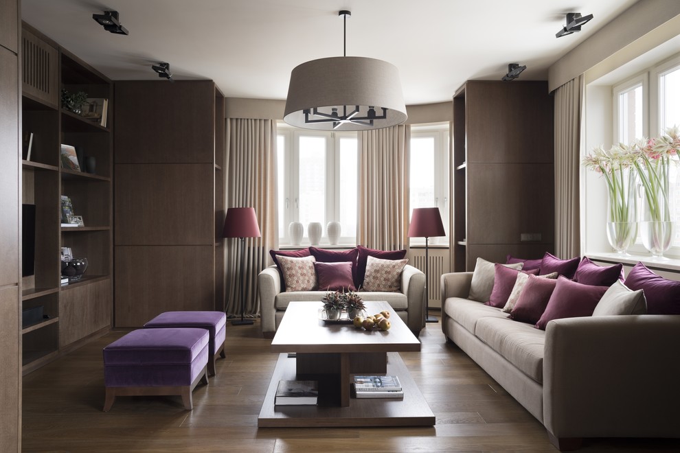 Esempio di un soggiorno design di medie dimensioni e aperto con pareti beige, pavimento in legno massello medio, nessun camino e TV a parete