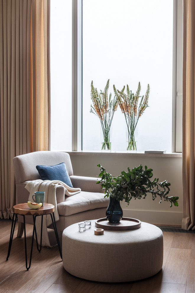Foto di un soggiorno design di medie dimensioni e aperto con pareti beige, pavimento in legno massello medio, libreria e pavimento marrone