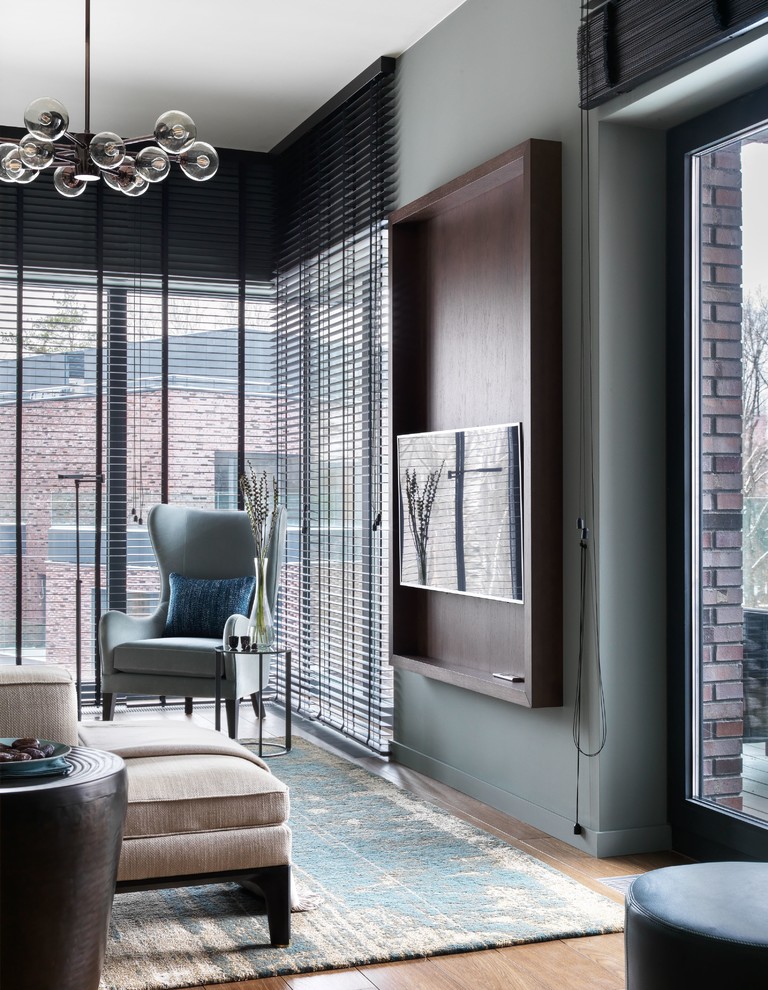 Источник вдохновения для домашнего уюта: гостиная комната среднего размера в современном стиле с серыми стенами, паркетным полом среднего тона, телевизором на стене и коричневым полом без камина