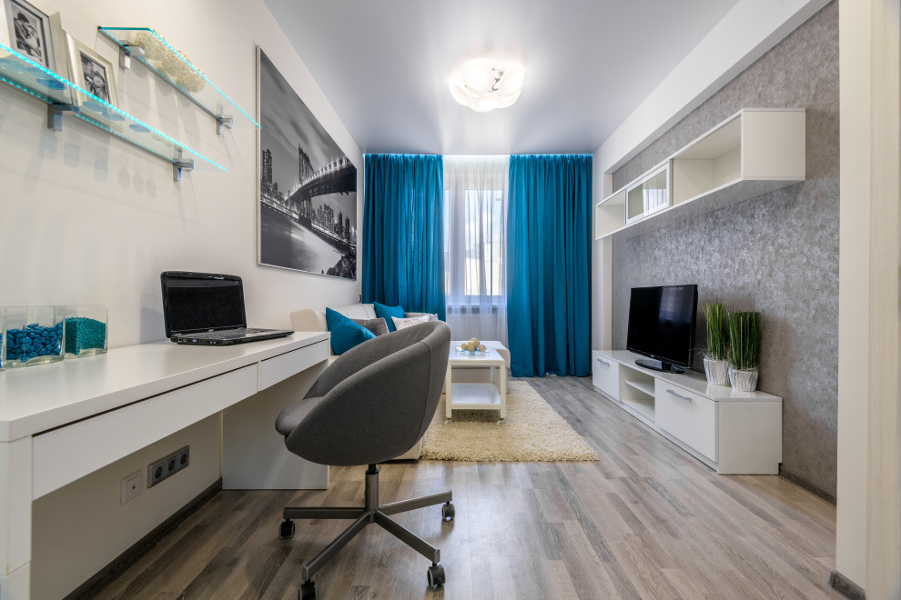 Immagine di un piccolo soggiorno contemporaneo con pareti bianche, pavimento in laminato, TV autoportante, pavimento grigio e carta da parati