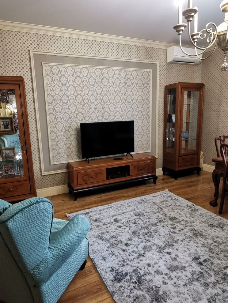 Classic enclosed living room in Novosibirsk with laminate floors and wallpapered walls.