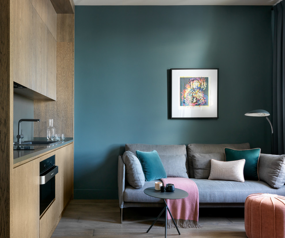 Kleines, Repräsentatives, Offenes Modernes Wohnzimmer mit blauer Wandfarbe, braunem Holzboden und braunem Boden in Moskau