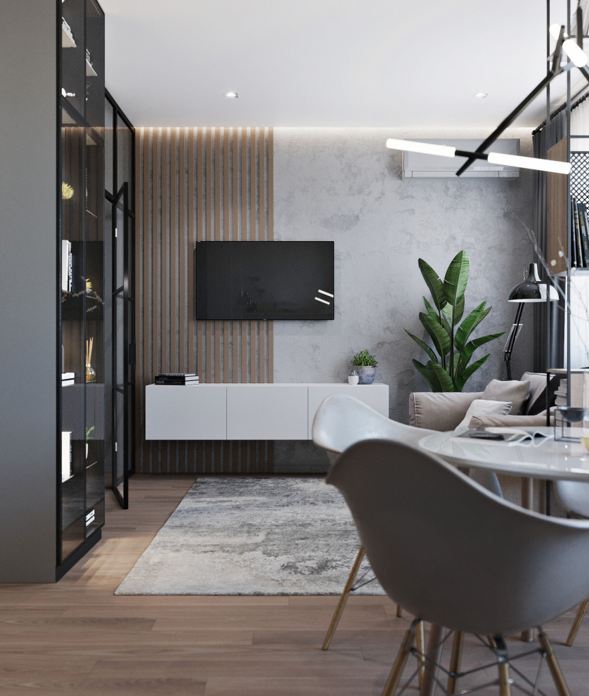 Diseño de salón abierto contemporáneo pequeño con paredes grises, suelo laminado y televisor colgado en la pared