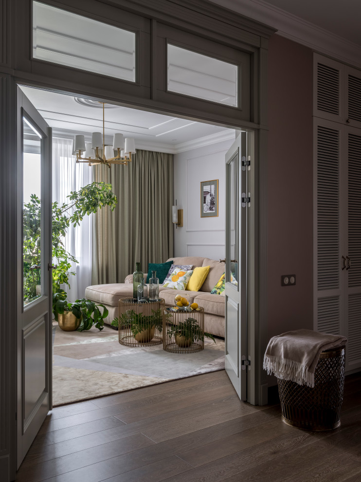 Foto di un soggiorno tradizionale di medie dimensioni e chiuso con libreria, pareti beige, pavimento in legno massello medio, TV a parete e pavimento marrone