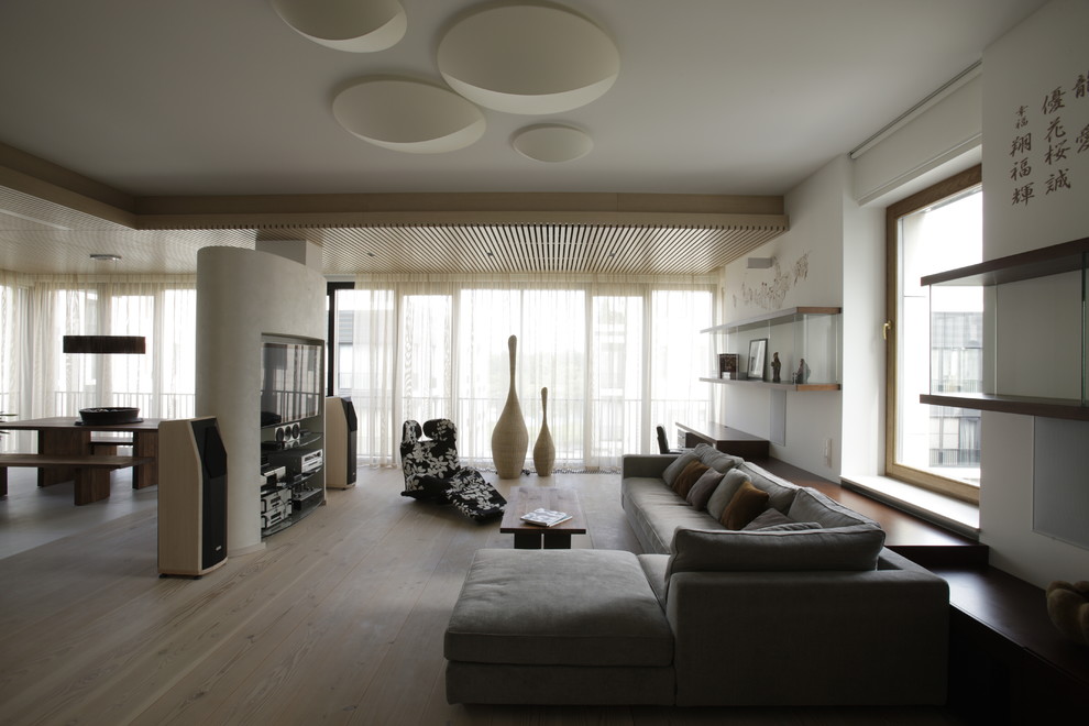 Diseño de salón para visitas abierto actual con paredes blancas y suelo de madera clara