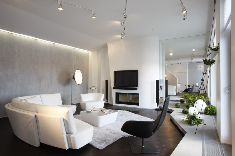 Idée de décoration pour un salon design ouvert avec une salle de réception, une cheminée standard et un téléviseur fixé au mur.