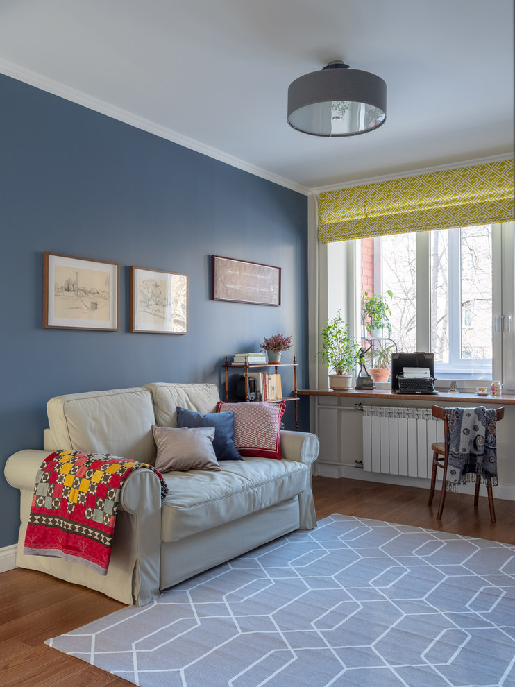 Ejemplo de salón cerrado vintage pequeño sin chimenea y televisor con paredes azules, suelo de madera en tonos medios y suelo marrón
