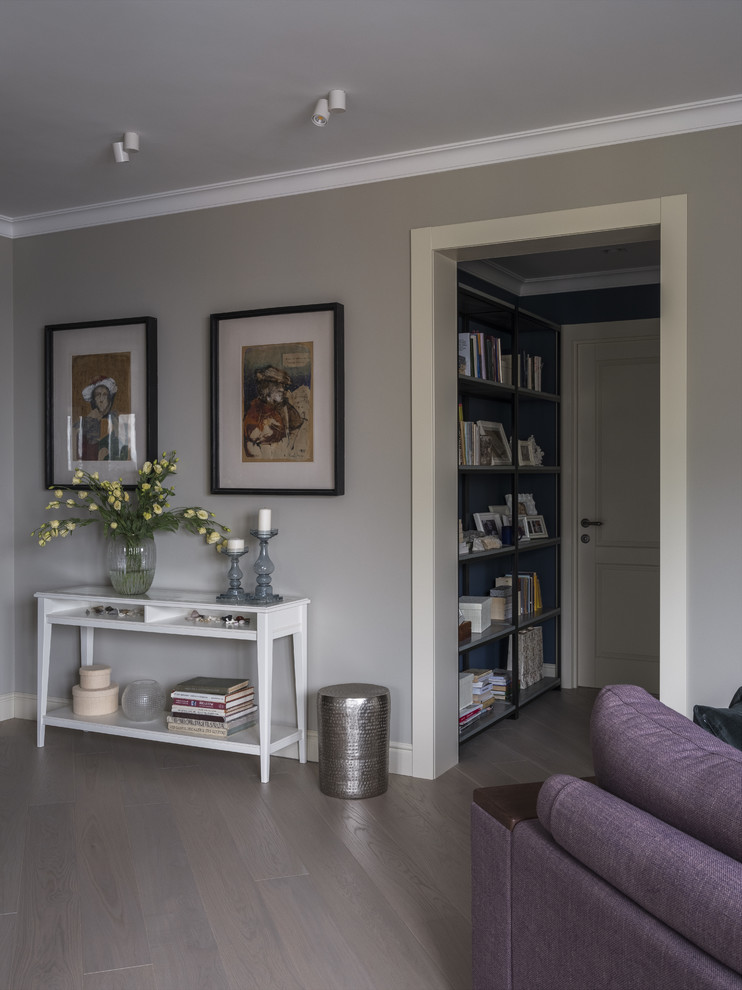 Ejemplo de salón para visitas abierto tradicional renovado de tamaño medio con paredes grises, suelo de madera clara, televisor colgado en la pared y suelo gris