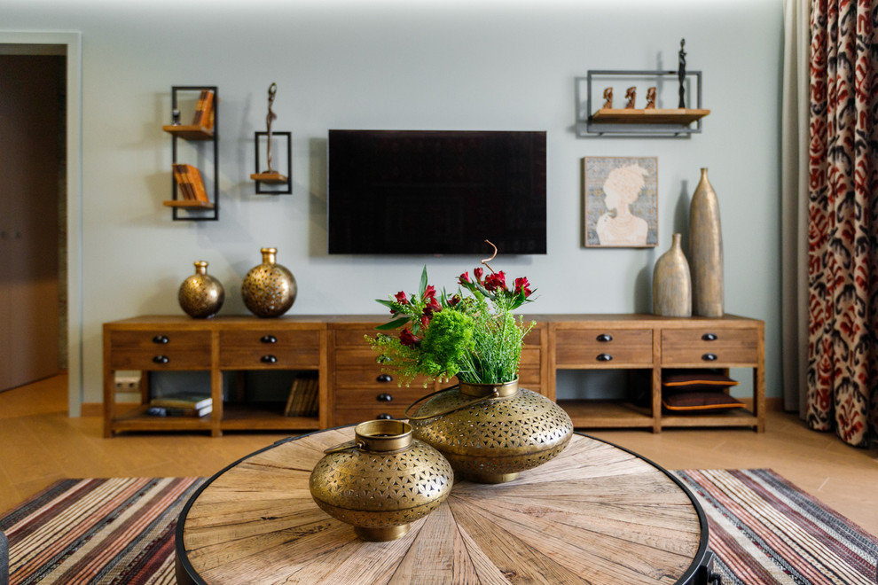 Стильный дизайн: гостиная комната среднего размера в восточном стиле с телевизором на стене - последний тренд