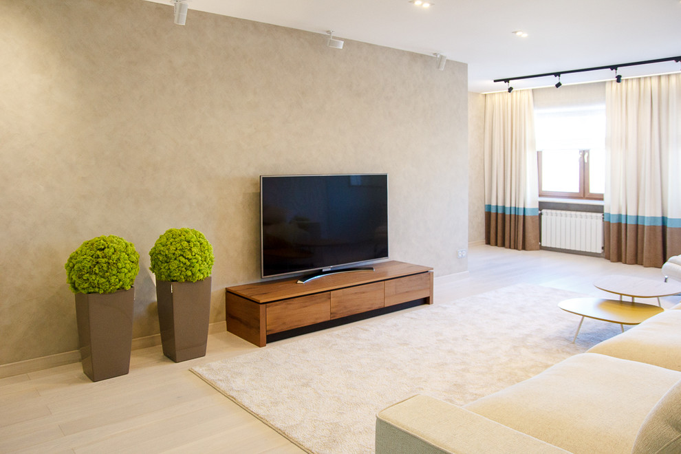 Cette image montre un grand salon design fermé avec un mur beige, parquet clair et un téléviseur encastré.