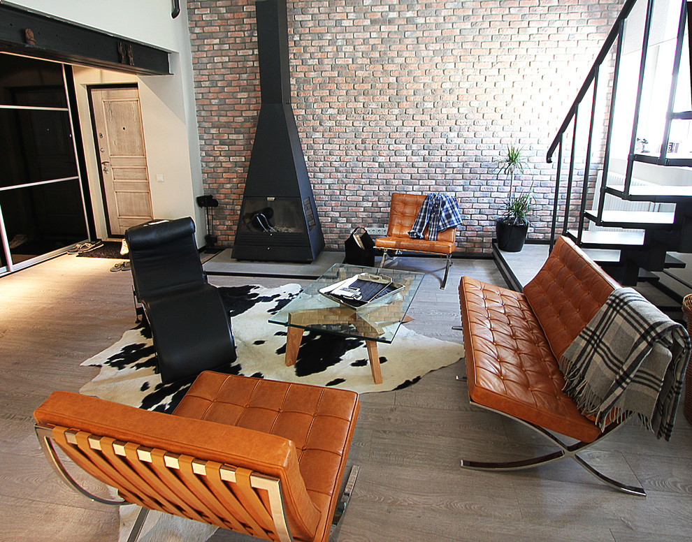 Идея дизайна: парадная, двухуровневая гостиная комната среднего размера в стиле лофт с стандартным камином, фасадом камина из металла, бежевым полом и телевизором на стене