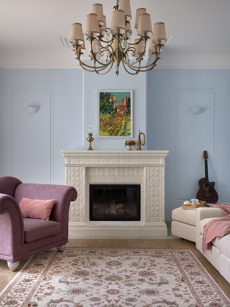 На фото: гостиная комната в классическом стиле с синими стенами, стандартным камином и фасадом камина из плитки с