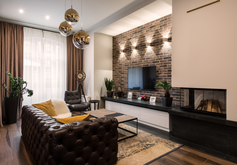 Пример оригинального дизайна: открытая гостиная комната в современном стиле с коричневыми стенами, темным паркетным полом, стандартным камином, телевизором на стене и коричневым полом