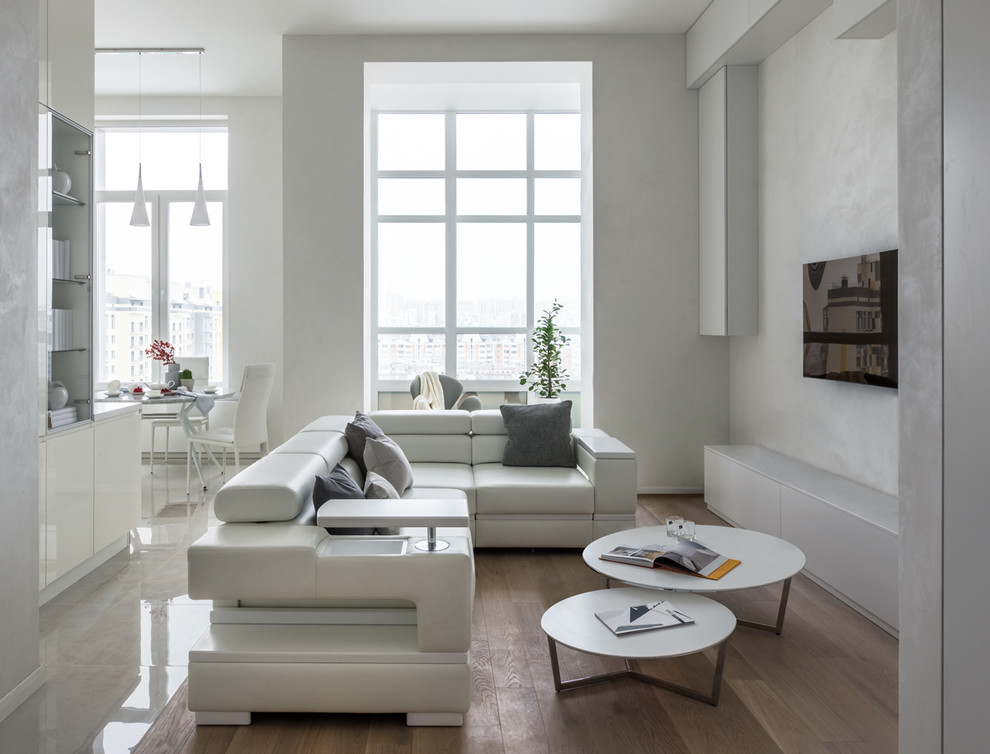 Mittelgroßes, Offenes, Repräsentatives Modernes Wohnzimmer ohne Kamin mit braunem Holzboden, TV-Wand, weißer Wandfarbe und braunem Boden in Moskau