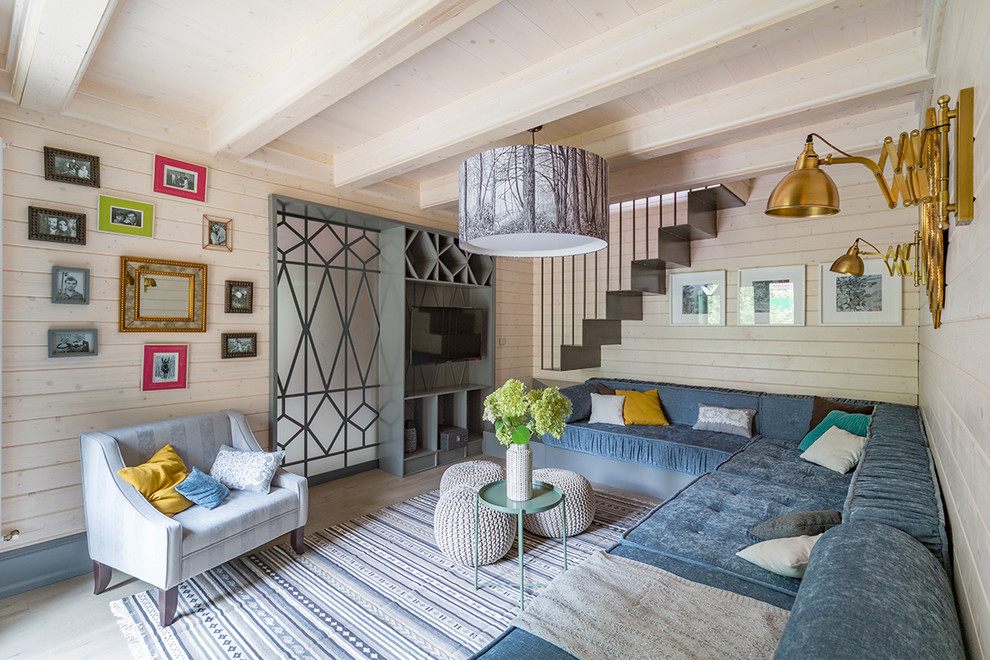 Пример оригинального дизайна: гостиная комната в современном стиле с бежевыми стенами, телевизором на стене и тюлем на окнах