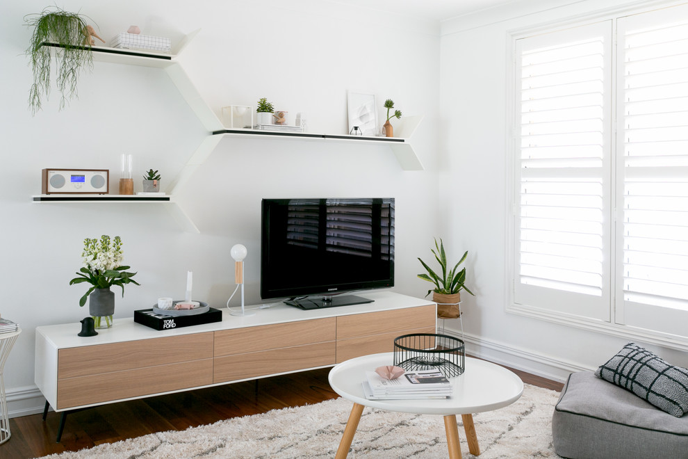 This is an example of a medium sized scandi open plan living room in Moscow with white walls, medium hardwood flooring, no fireplace and a freestanding tv.