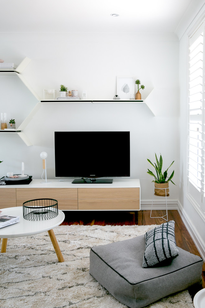На фото: открытая гостиная комната среднего размера в скандинавском стиле с белыми стенами, паркетным полом среднего тона и отдельно стоящим телевизором без камина