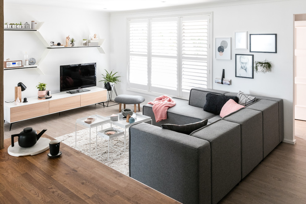 Design ideas for a medium sized scandi open plan living room in Moscow with white walls, medium hardwood flooring, no fireplace and a freestanding tv.