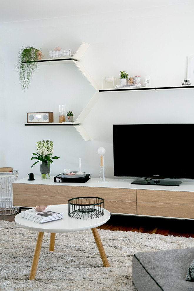 На фото: открытая гостиная комната среднего размера в скандинавском стиле с белыми стенами, паркетным полом среднего тона и отдельно стоящим телевизором без камина