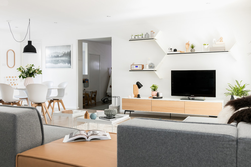 Foto de salón abierto nórdico de tamaño medio sin chimenea con paredes blancas, suelo de madera en tonos medios y televisor independiente
