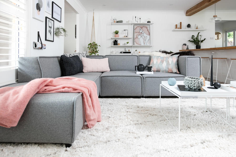 Imagen de salón abierto nórdico de tamaño medio sin chimenea con paredes blancas, suelo de madera en tonos medios y televisor independiente