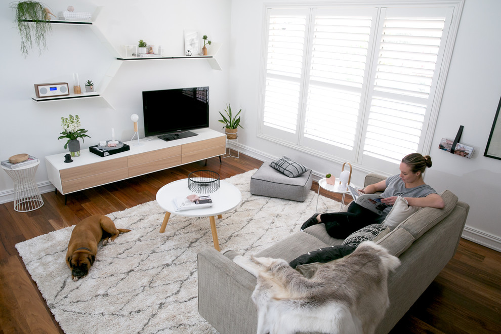 Источник вдохновения для домашнего уюта: открытая гостиная комната среднего размера в скандинавском стиле с белыми стенами, паркетным полом среднего тона и отдельно стоящим телевизором без камина