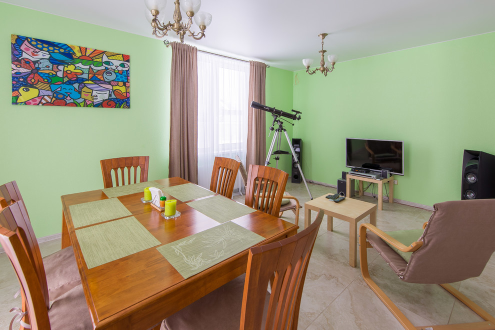 Cette image montre un salon traditionnel de taille moyenne et ouvert avec un mur vert, un sol en carrelage de porcelaine et un téléviseur fixé au mur.