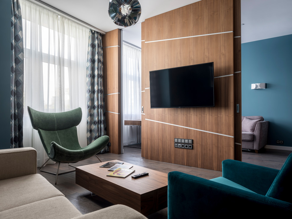 На фото: маленькая открытая гостиная комната в современном стиле с синими стенами, паркетным полом среднего тона, телевизором на стене, коричневым полом и деревянными стенами для на участке и в саду