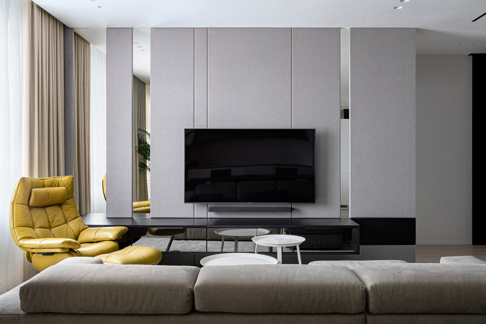 Свежая идея для дизайна: гостиная комната в современном стиле с серыми стенами и телевизором на стене - отличное фото интерьера