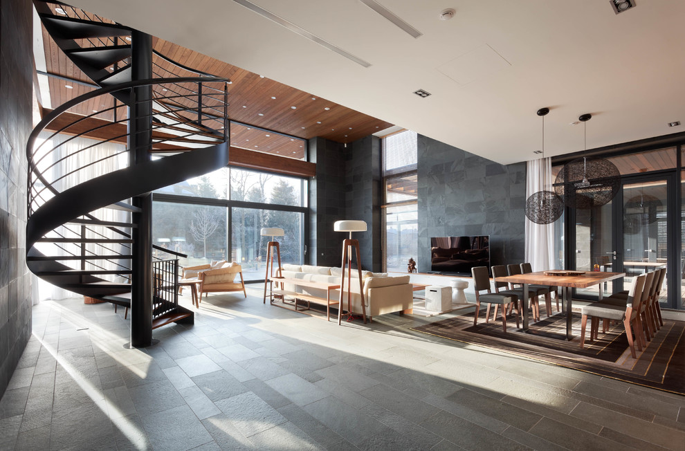 Immagine di un grande soggiorno design aperto con pareti multicolore, pavimento in ardesia, pavimento grigio e TV autoportante