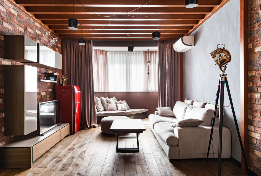 На фото: открытая гостиная комната среднего размера в стиле лофт с разноцветными стенами, паркетным полом среднего тона и отдельно стоящим телевизором