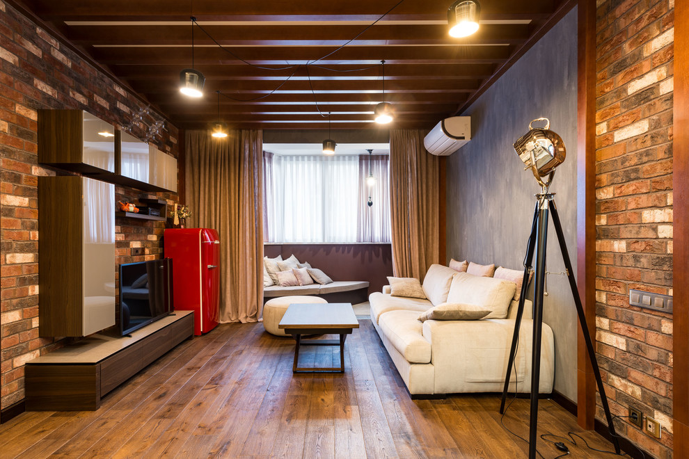 Esempio di un soggiorno industriale di medie dimensioni e stile loft con pavimento in legno massello medio, TV autoportante, pavimento marrone e pareti multicolore