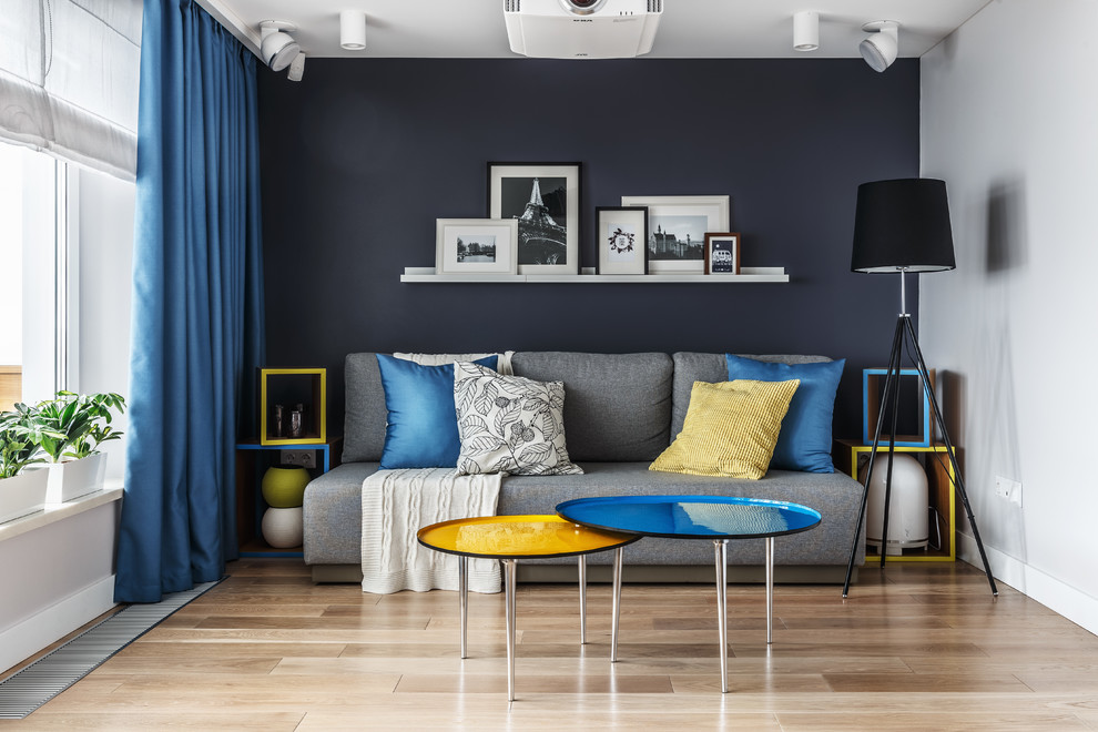 Idée de décoration pour un salon design fermé avec un mur bleu, un sol en bois brun et un sol marron.
