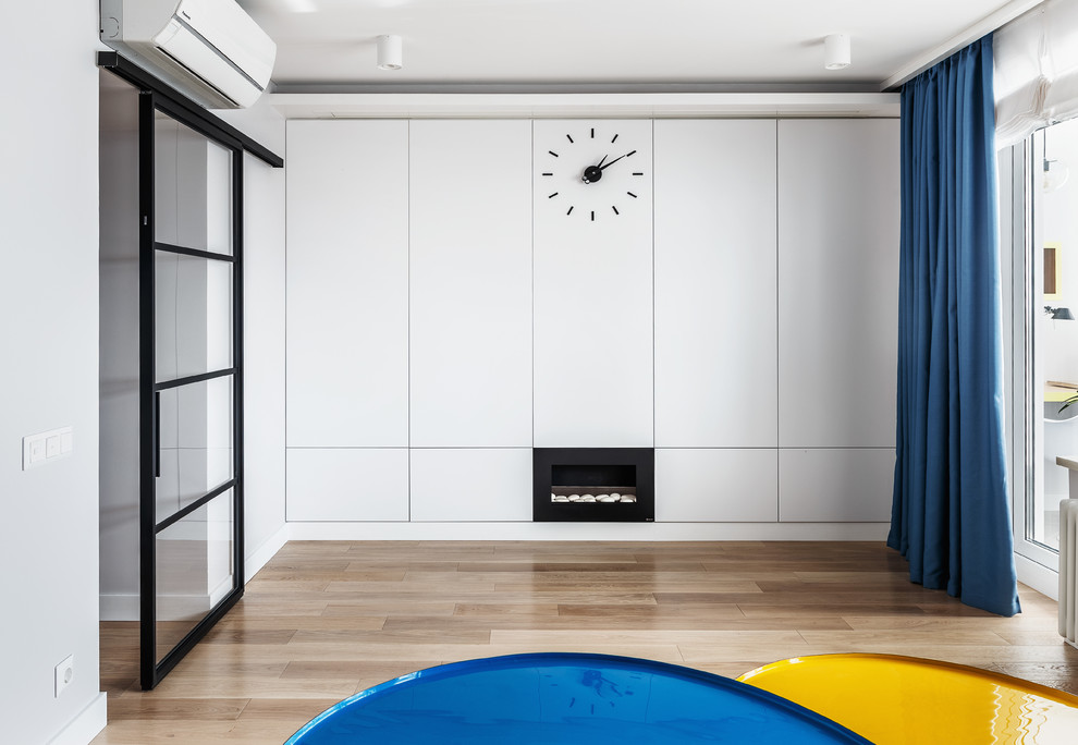 Immagine di un soggiorno minimal chiuso con pareti bianche, pavimento marrone e parquet chiaro