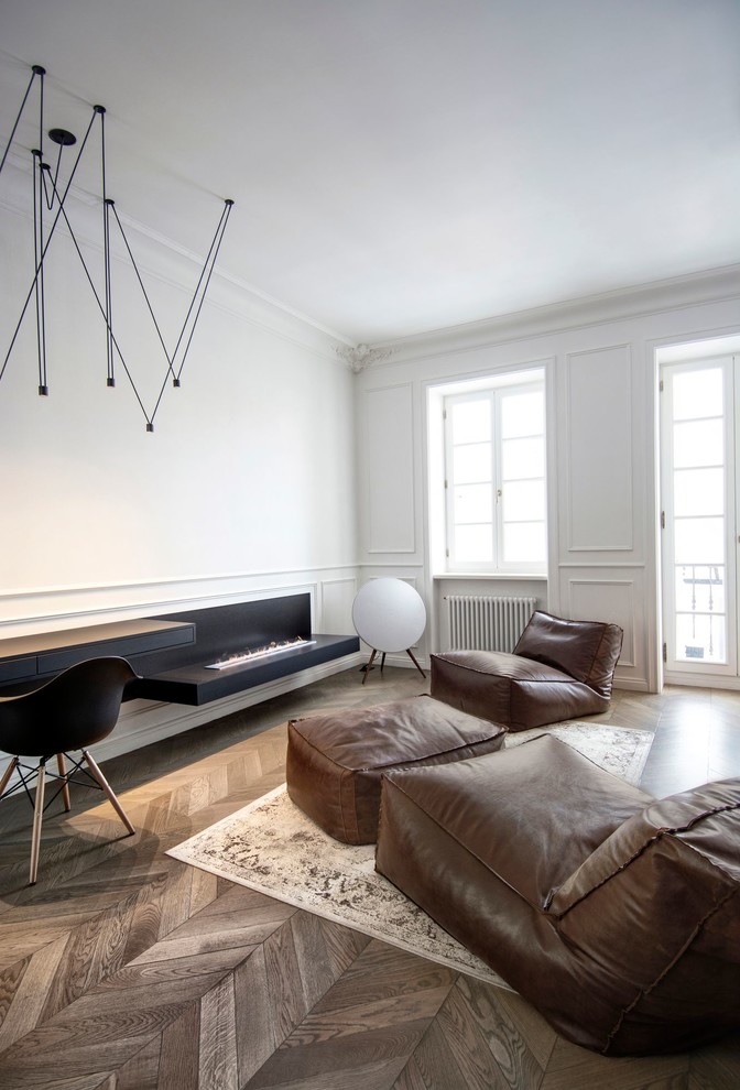Modelo de salón para visitas abierto escandinavo pequeño sin televisor con paredes blancas, suelo de madera en tonos medios y chimenea lineal