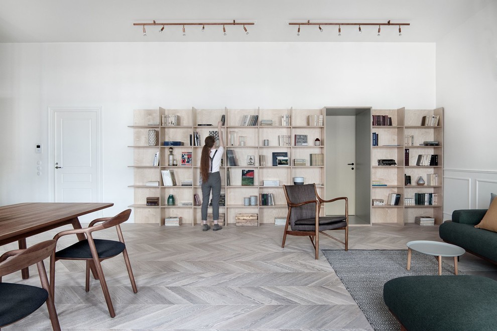Esempio di un grande soggiorno contemporaneo aperto con libreria, pareti bianche, parquet chiaro e pavimento grigio