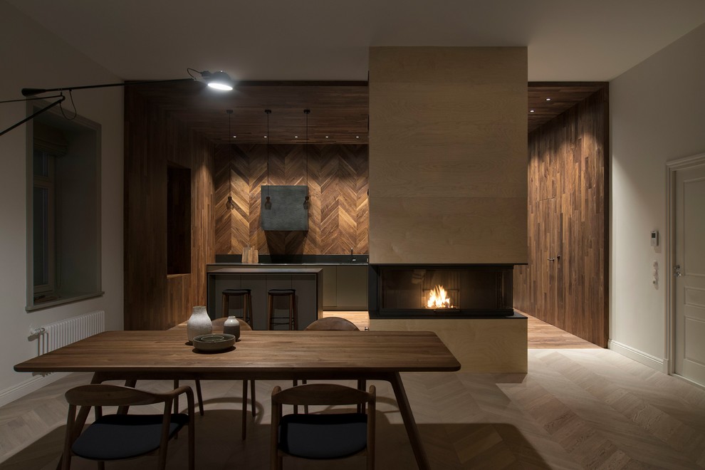 高級な広いコンテンポラリースタイルのおしゃれなLDK (白い壁、淡色無垢フローリング、木材の暖炉まわり、白い床、標準型暖炉) の写真