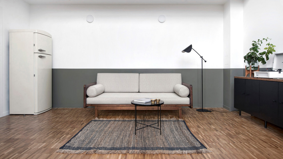 Modelo de salón tipo loft minimalista de tamaño medio con paredes blancas, suelo de madera en tonos medios y suelo marrón
