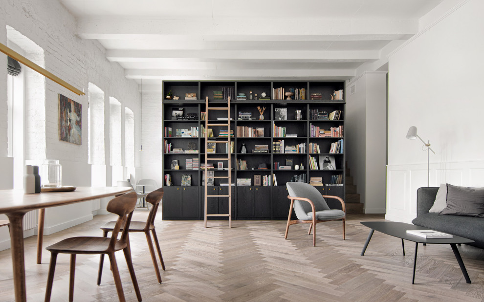 Exemple d'un salon mansardé ou avec mezzanine tendance de taille moyenne avec une bibliothèque ou un coin lecture, un mur blanc, un sol en bois brun, un sol marron et poutres apparentes.