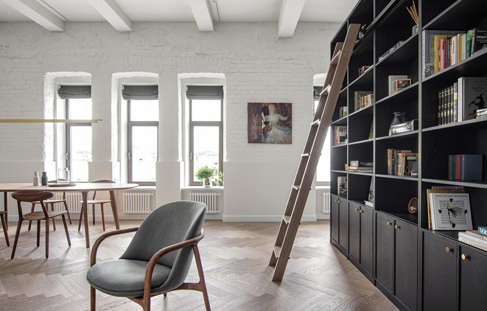 Foto de biblioteca en casa tipo loft contemporánea de tamaño medio con paredes blancas, suelo de madera en tonos medios, suelo marrón y vigas vistas
