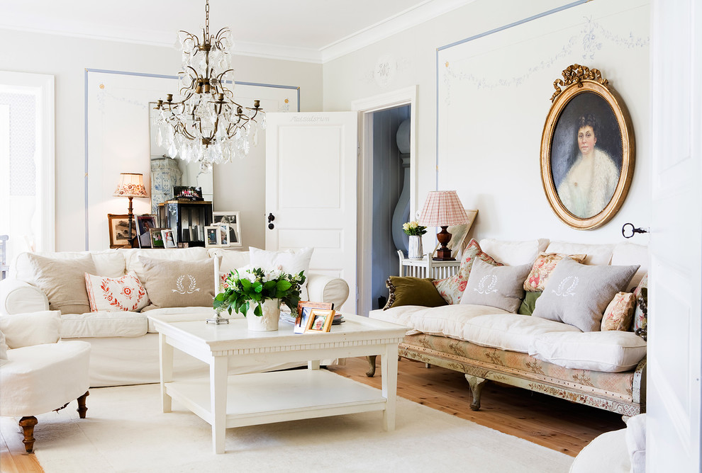 Repräsentatives Shabby-Look Wohnzimmer mit weißer Wandfarbe und hellem Holzboden in Sonstige