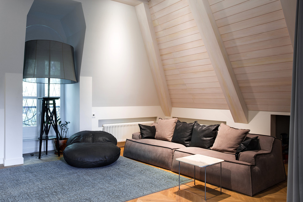 Свежая идея для дизайна: гостиная комната в современном стиле с белыми стенами, паркетным полом среднего тона и коричневым диваном без камина - отличное фото интерьера