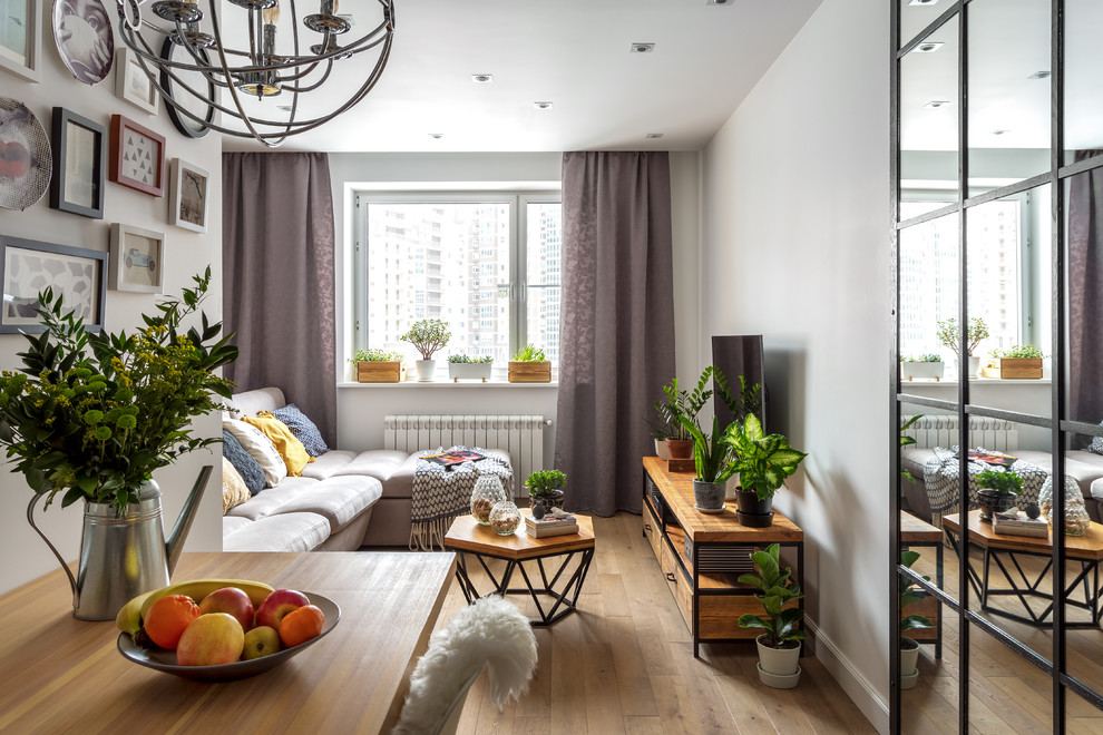 Стильный дизайн: открытая, объединенная гостиная комната среднего размера в скандинавском стиле с телевизором на стене, белыми стенами и светлым паркетным полом - последний тренд