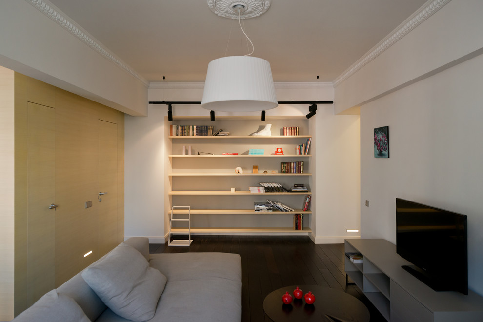 Пример оригинального дизайна: открытая гостиная комната среднего размера в современном стиле с с книжными шкафами и полками, белыми стенами, темным паркетным полом и отдельно стоящим телевизором