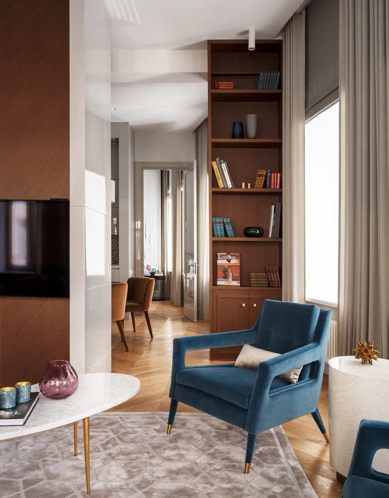 Свежая идея для дизайна: большая открытая, объединенная гостиная комната в современном стиле с с книжными шкафами и полками, серыми стенами, светлым паркетным полом и телевизором на стене - отличное фото интерьера