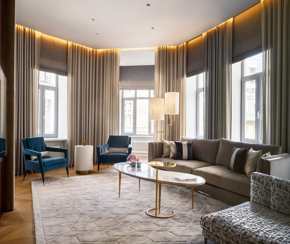 Стильный дизайн: большая открытая, парадная гостиная комната в современном стиле с серыми стенами, светлым паркетным полом и телевизором на стене - последний тренд