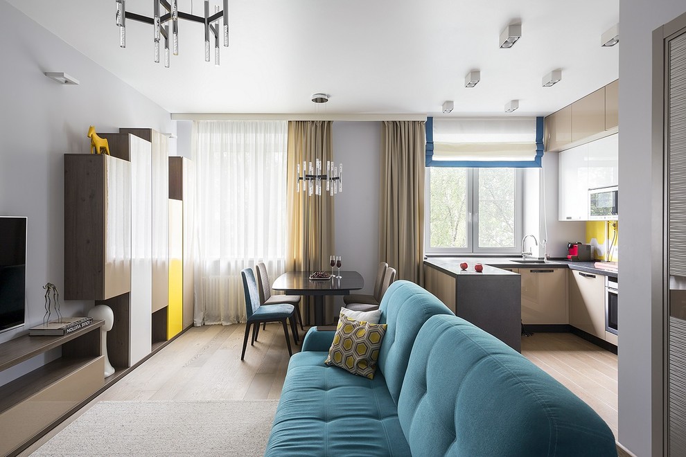 Источник вдохновения для домашнего уюта: открытая гостиная комната в современном стиле с серыми стенами, телевизором на стене, светлым паркетным полом и бежевым полом без камина