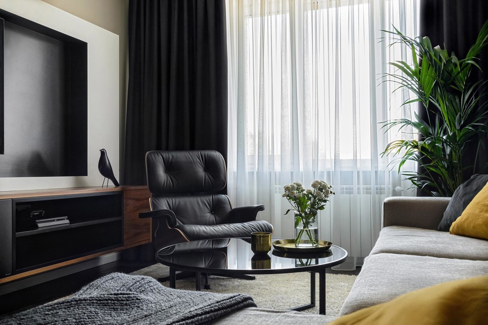 На фото: гостиная комната в современном стиле с телевизором на стене