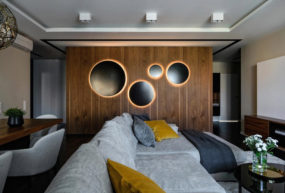 Стильный дизайн: объединенная гостиная комната в современном стиле с телевизором на стене - последний тренд