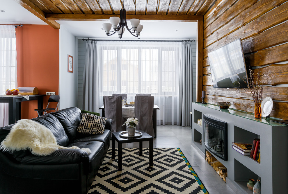 Offenes Klassisches Wohnzimmer mit TV-Wand, oranger Wandfarbe und Gaskamin in Moskau